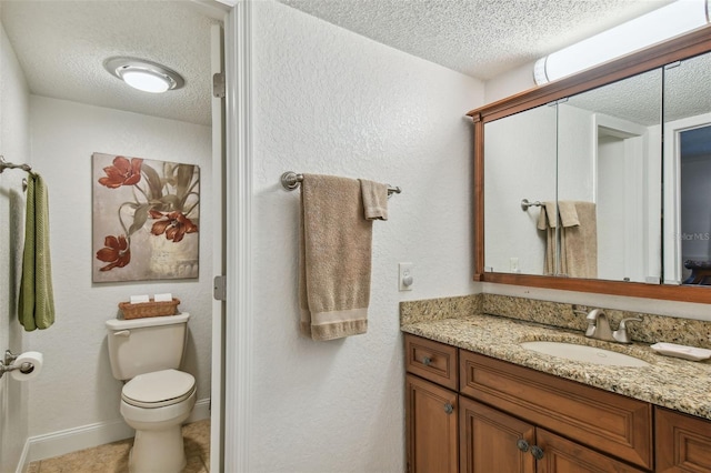 bathroom featuring tile patterned floors, toilet, vanity, and a textured ceiling