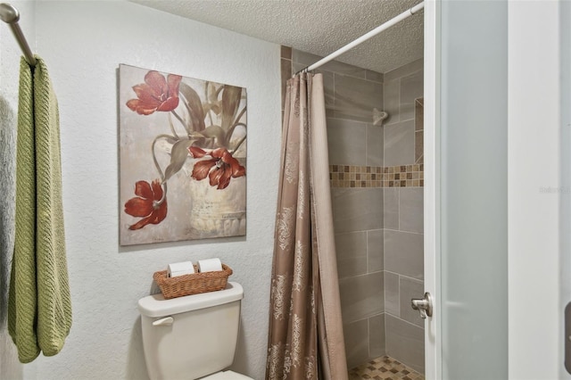 bathroom featuring a textured ceiling, toilet, and a shower with shower curtain