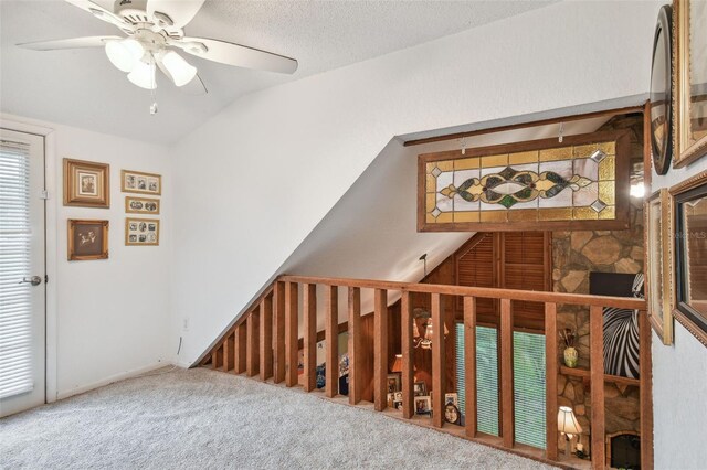 interior space featuring vaulted ceiling, a textured ceiling, and carpet flooring