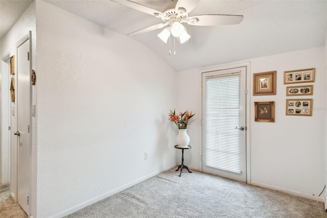 unfurnished room with a textured ceiling, light colored carpet, lofted ceiling, and ceiling fan