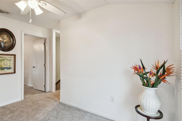 hallway with vaulted ceiling and light colored carpet