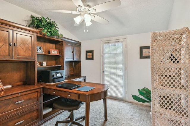 home office with a textured ceiling, ceiling fan, vaulted ceiling, and light colored carpet