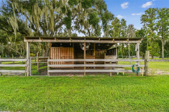 view of stable featuring a yard and an outbuilding