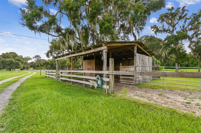 view of stable featuring an outdoor structure and a lawn