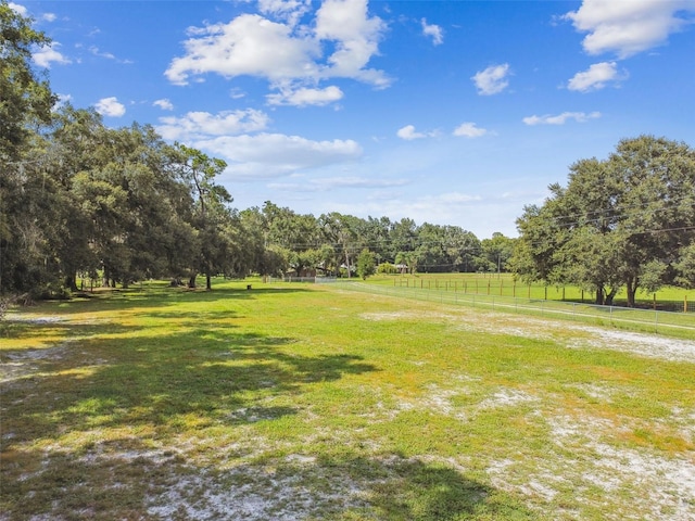 view of property's community featuring a lawn and a rural view