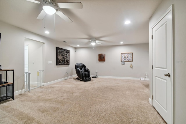 living area with light carpet and ceiling fan