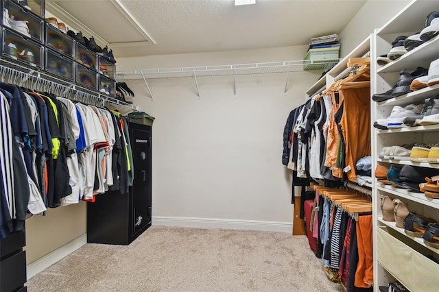 walk in closet featuring light colored carpet