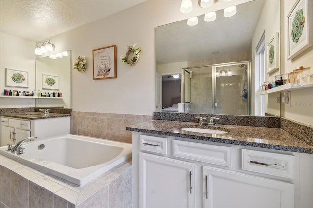 bathroom with vanity, a textured ceiling, and separate shower and tub