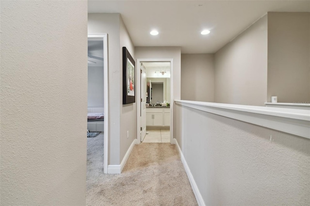 hall with light colored carpet