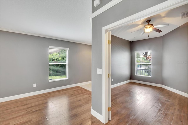 empty room featuring wood-type flooring, crown molding, and ceiling fan