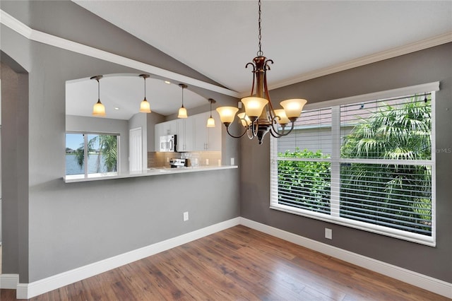 unfurnished dining area featuring wood-type flooring, lofted ceiling, and an inviting chandelier