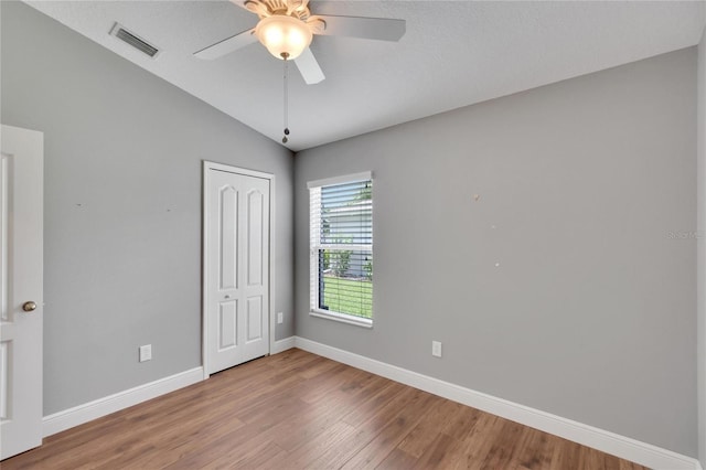 spare room featuring ceiling fan, wood-type flooring, and vaulted ceiling