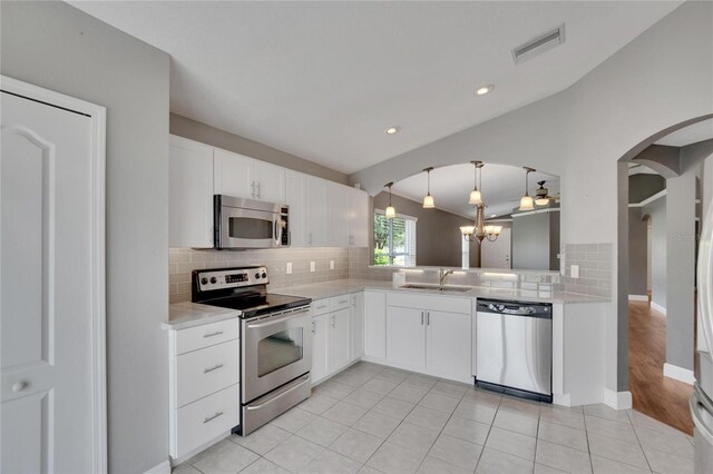 kitchen with pendant lighting, white cabinetry, sink, a chandelier, and stainless steel appliances