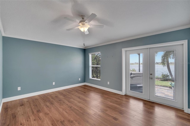 empty room featuring crown molding, french doors, and a water view