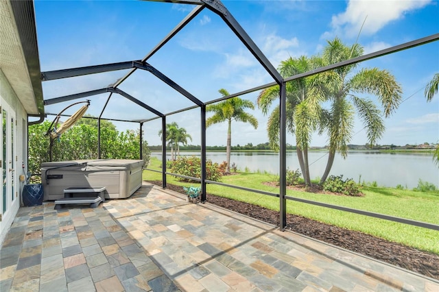 view of patio featuring a lanai, a hot tub, and a water view