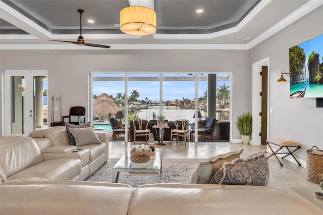 living room with a tray ceiling and ceiling fan