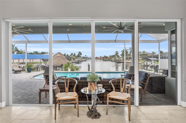 interior space with a water view and ceiling fan