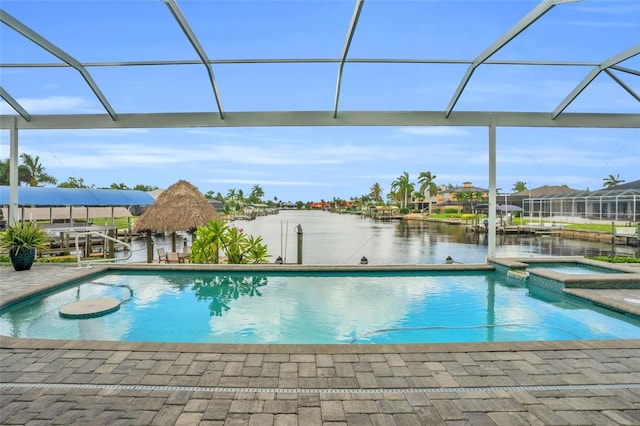 view of pool featuring a patio, a water view, glass enclosure, and an in ground hot tub