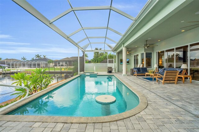 view of pool featuring a patio area, a water view, outdoor lounge area, a lanai, and ceiling fan