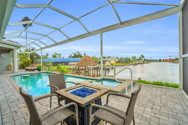 view of swimming pool with a patio, a water view, an in ground hot tub, and a lanai