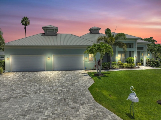 view of front of house featuring a garage and a yard