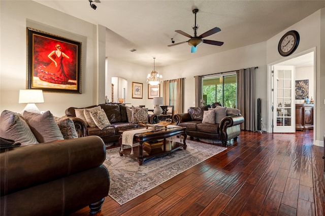 living room featuring ceiling fan with notable chandelier and dark hardwood / wood-style flooring