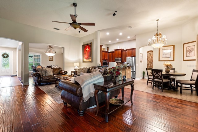 living room featuring tile patterned flooring and ceiling fan with notable chandelier