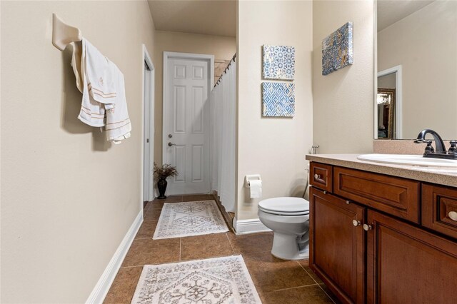 bathroom with vanity, tile patterned flooring, and toilet