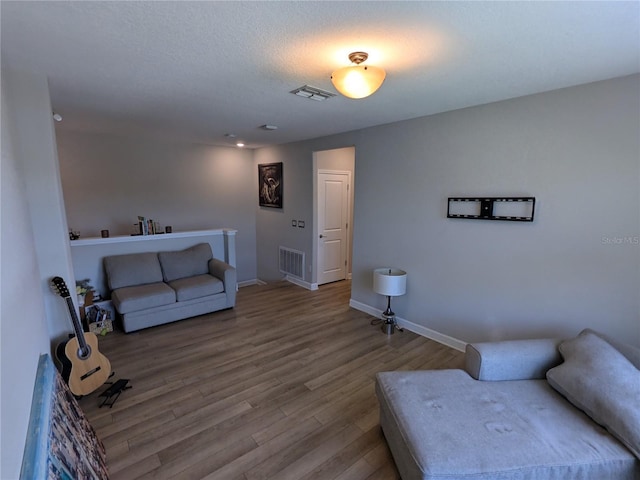 living room featuring hardwood / wood-style flooring and a textured ceiling