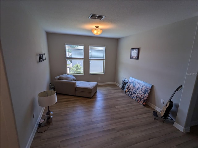 sitting room with hardwood / wood-style flooring and a textured ceiling