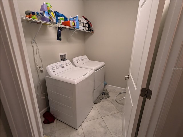 washroom with washing machine and clothes dryer and light tile patterned floors