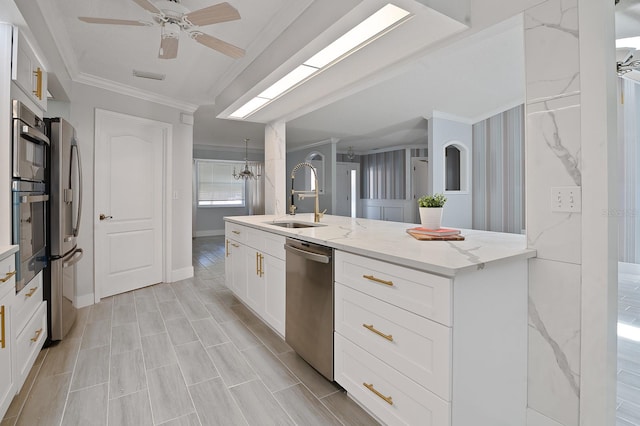 kitchen with stainless steel appliances, sink, light stone countertops, white cabinetry, and ornamental molding