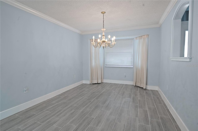 spare room featuring an inviting chandelier, crown molding, and a textured ceiling