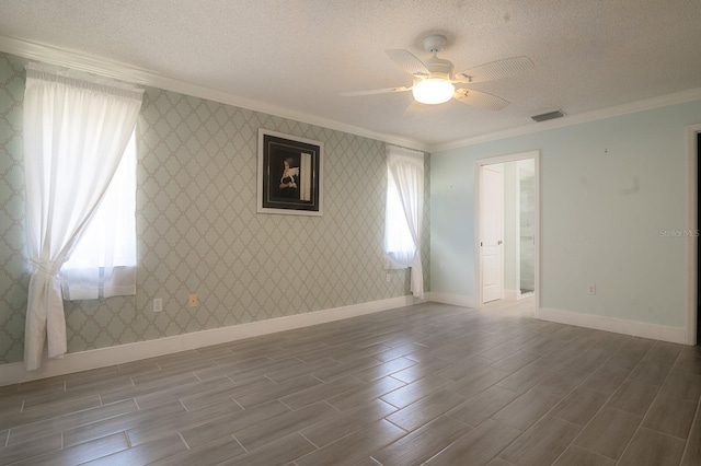 empty room featuring crown molding, a textured ceiling, ceiling fan, and wood-type flooring