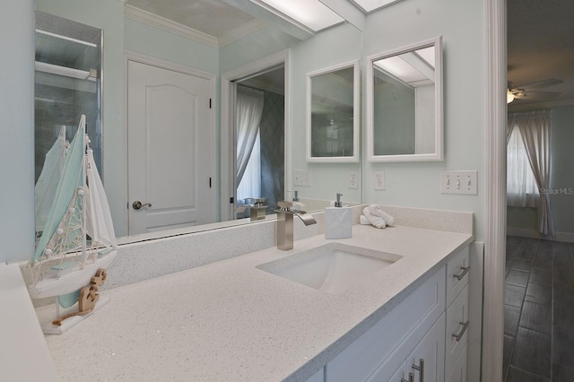 bathroom with crown molding, vanity, and ceiling fan