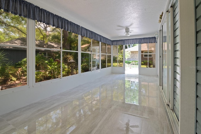 unfurnished sunroom featuring ceiling fan