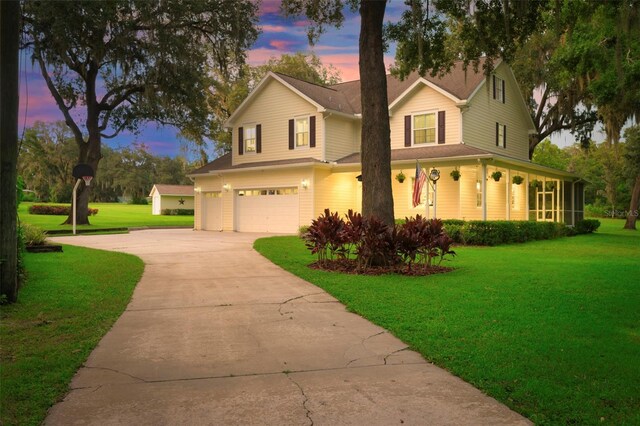 farmhouse inspired home with a garage and a lawn