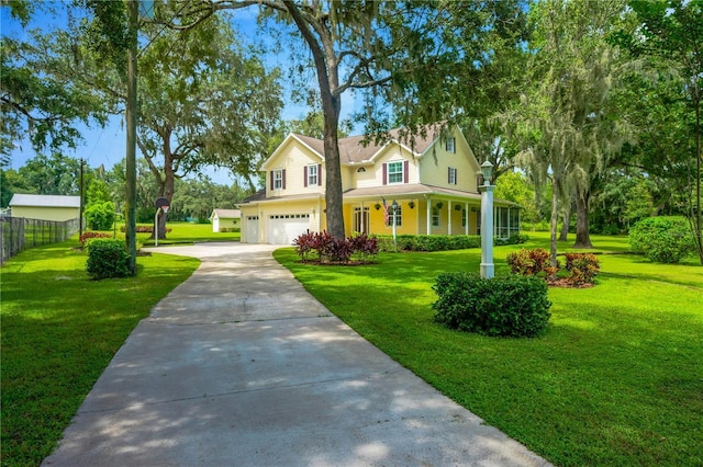 view of front of house with a garage, a front yard, and covered porch