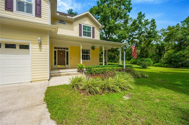 property entrance with a garage, covered porch, and a lawn