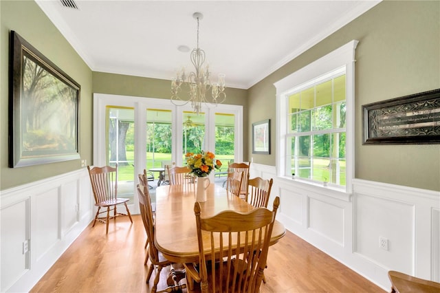 dining room with crown molding, a wealth of natural light, and a notable chandelier