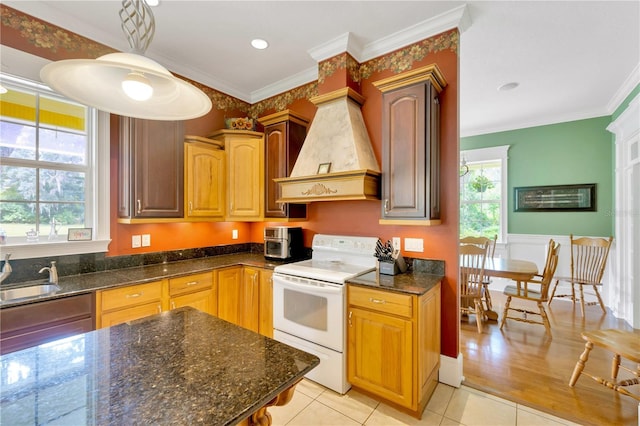 kitchen featuring custom exhaust hood, hanging light fixtures, light tile patterned floors, ornamental molding, and electric stove