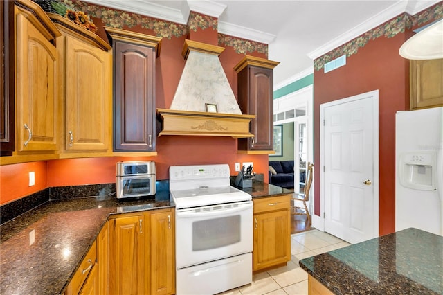 kitchen with light tile patterned flooring, custom range hood, crown molding, and white appliances