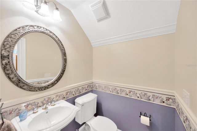 bathroom with ornamental molding, lofted ceiling, sink, and toilet