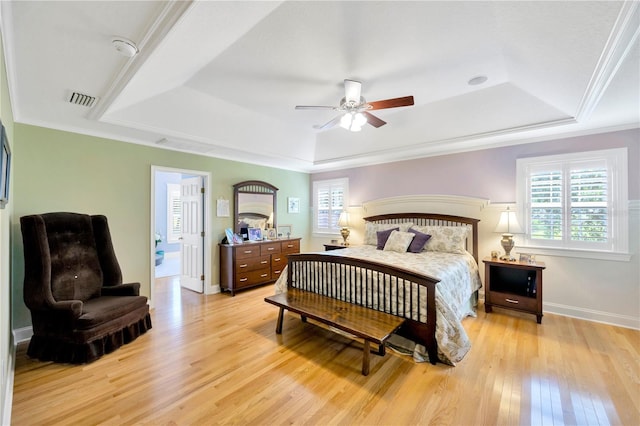 bedroom featuring multiple windows, crown molding, ceiling fan, and a tray ceiling