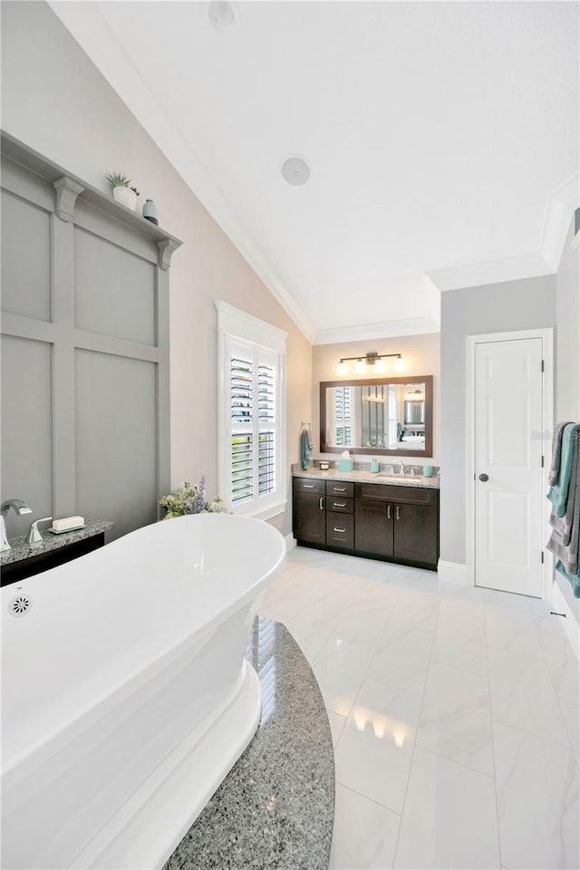 bathroom with vanity, lofted ceiling, crown molding, and a bathtub