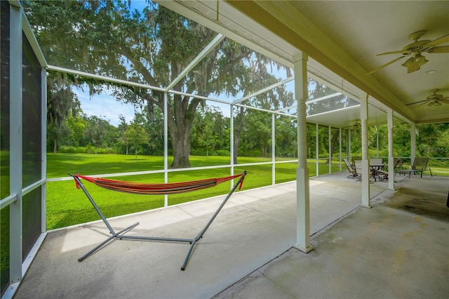 unfurnished sunroom with ceiling fan