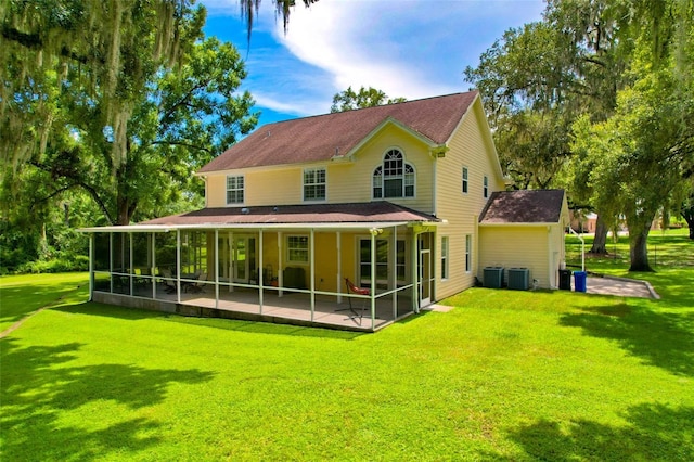 rear view of property with central AC, a sunroom, a lawn, and a patio area