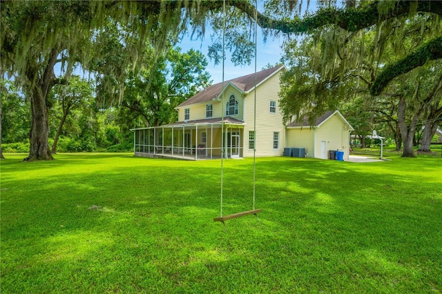 rear view of property with a sunroom and a lawn