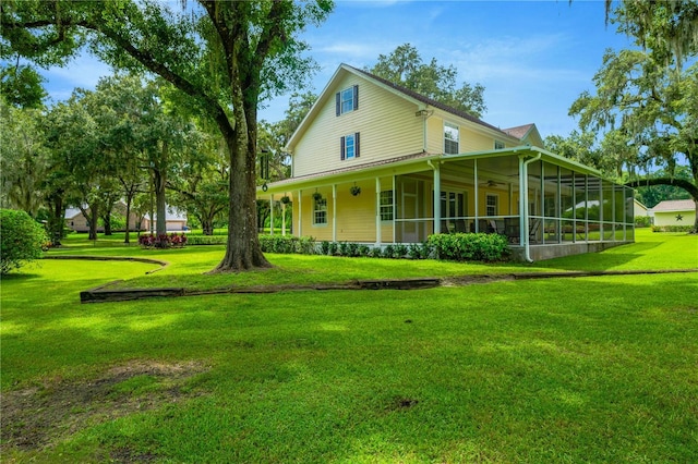 back of property with a yard and a sunroom