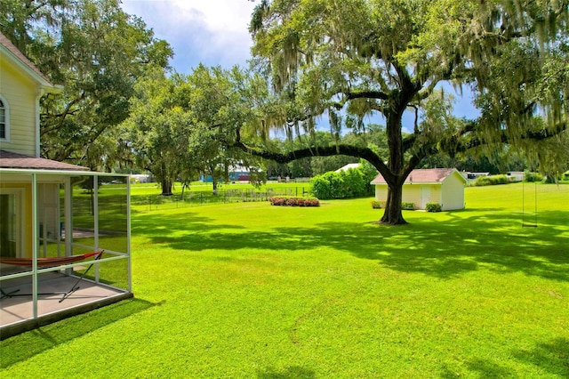 view of yard with a storage shed and a sunroom